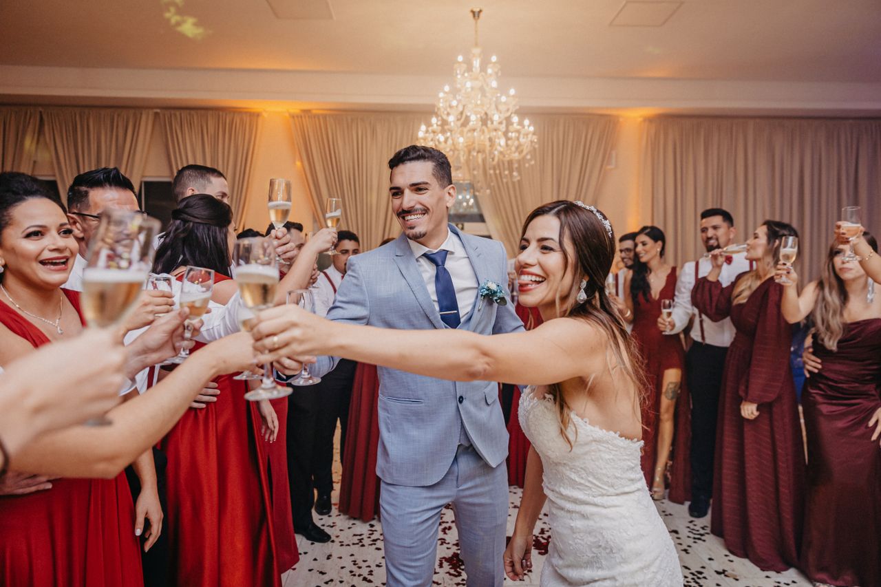 gallery-02 Happy couple and guests raise glasses for a joyful wedding toast indoors.