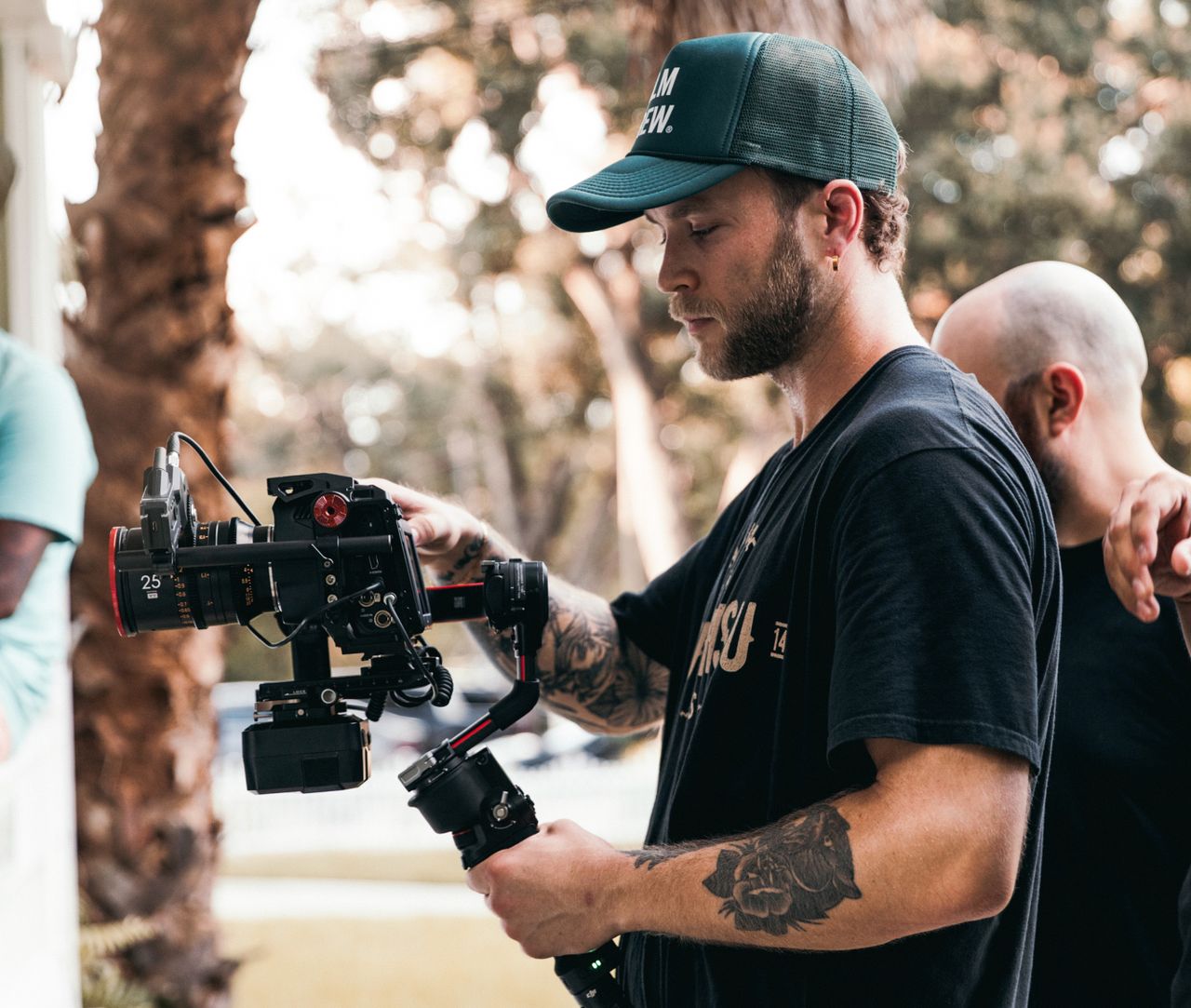 portfolio-01 Male videographer working with camera rig during outdoor shoot, showcasing filmmaking process.