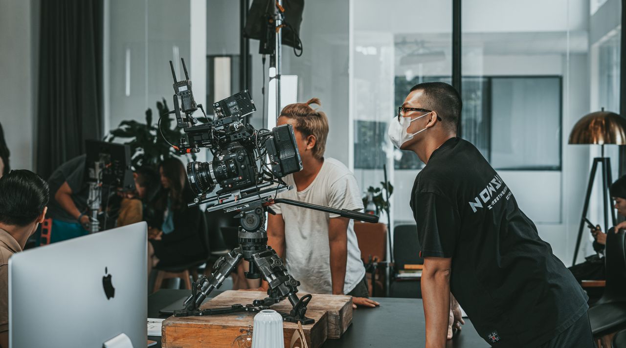 portfolio-02 A professional film crew collaborates in a modern studio setting, focusing on high-end camera equipment.